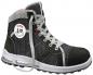 Preview: It is a robust, high-cut shoe in black and gray. The laces are gray, with a white sole and a round, red-white logo on the side.