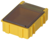 Preview: The image shows a small, yellow plastic box with a transparent top. The box has a rectangular shape and structure with grooves on the sides. It is sturdy and moderately firm.