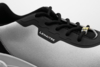 Preview: The image shows a close-up of a sports shoe. The shoe has a gray upper with black details and laces. On the side, there is the "Lemaitre" logo.