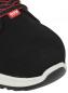 Preview: The image displays the front view of a black sports shoe with a round, white sole. The laces are red and black, and the fabric appears soft and durable.