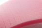 Preview: The image shows a pink foam surface with fine, parallel grooves. The structure is soft and has a slightly curved shape. It conveys a sense of flexibility.