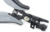 Preview: The image shows a pair of pliers with an ergonomic handle and a spring-loaded mechanism. It has a silver rotating knob and a black edge that allows for precise operation.