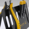 Preview: The image shows a tool fork with a pair of pliers that have yellow and black grip areas. Next to it are three black markers with yellow caps on a black holder.