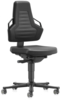 Preview: The chair is completely black and has a high backrest with soft, dimpled indentations. It stands on five casters and has side armrests. The seat is flat and wide.