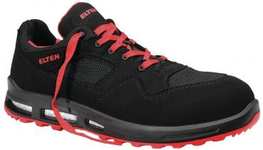 The shoe is sporty and predominantly black, with red laces and accents. The sole is sturdy and features a striking design that provides good grip.