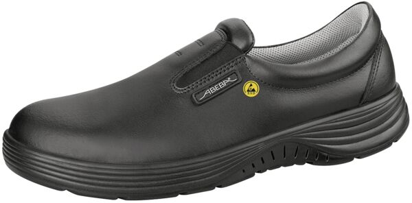 The shoe is a black slip-on with a smooth upper. It has a lightweight sole with tread and a small yellow marking on the side. Ideal for use in the hospitality or healthcare industry.