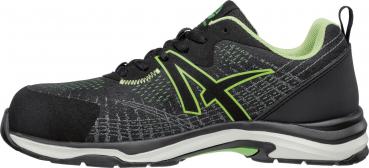 The shoe is predominantly black with green accents. It has a sporty shape, a light sole, and laces. The upper material appears textured and sturdy.