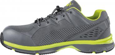 It is a gray sports shoe with yellow accents. It features a breathable, textured upper, a solid rubber sole, and a lace-up closure for a secure fit.