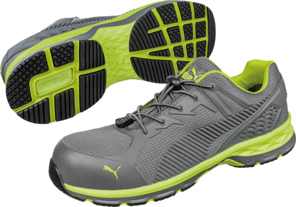 The image shows a pair of gray sports shoes with green accents. They have a flexible sole with a grippy tread and laces. The shoes are designed to be modern and sporty.