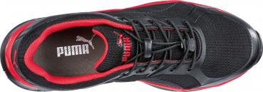 The shoe is black with red accents. It has laces on top and a breathable mesh material. The insole features the Puma logo. It appears sporty and modern.