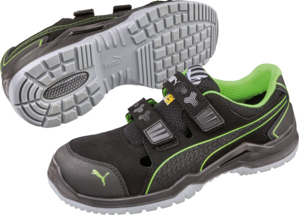 The image shows fashionable black sports shoes with green accents. They have a non-slip, gray sole and two wide Velcro straps on the top.