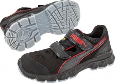 The image shows a sporty shoe in black with red accents. The shoe has a flat, non-slip tread and a Velcro fastener instead of laces.