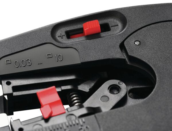 The image shows a part of a device with a black matte surface. There are red-colored switches and a counter ranging from 0.03 to 10. Mechanical parts are visible.