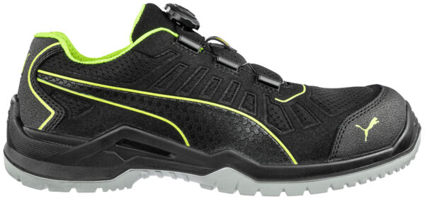 The shoe is sporty and black with green accents. It has a textured surface, a braided lace-up closure, and a sturdy rubber sole for good grip.