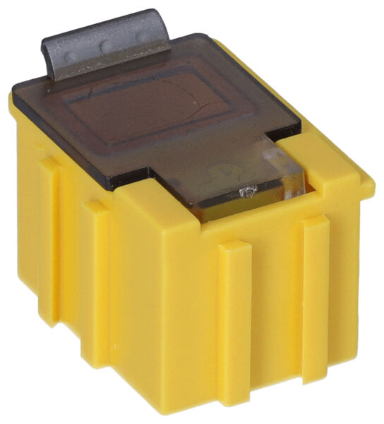 The image shows a yellow, square electrical plug with a transparent top. The corners are rounded, and a small metal contact is visible on the top.