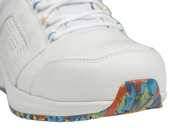 The image shows the front part of a white sports shoe. The sole features a colorful, abstract pattern in blue, yellow, and red. The laces are white and the surface has small ventilation holes.