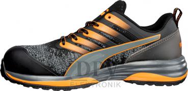 Der Schuh ist sportlich und modern, in Schwarz mit orangefarbenen und grauen Akzenten. Er hat eine gepolsterte Sohle und Schnürsenkel, ideal für Komfort und Sicherheit.