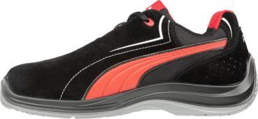 The shoe is black with red accents. It has a smooth surface made of leather and textile, a flexible sole, and is designed sporty. The shoelaces are also black.