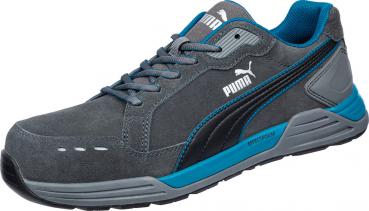 The shoe is sporty, made of gray suede with blue accents. It has a sturdy sole, laces, and the Puma logo on the side. It looks comfortable and modern.