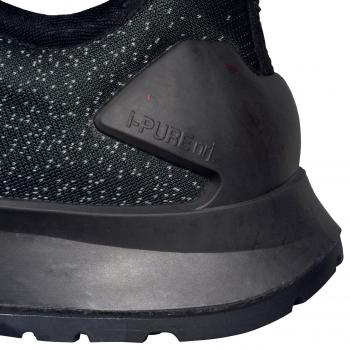 The image shows a part of a sports shoe with a textured, black upper. The sole is slightly shaped, with a prominent, stabilizing element at the heel.