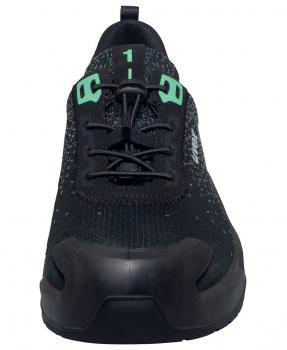 The shoe is black with slightly shiny, textured surfaces. It has green laces and a sturdy, round toe. The sole is robust and well-cushioned.