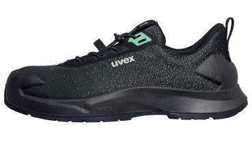 The image shows a black sports shoe with a green logo. It has a sturdy, non-slip sole and a flexible, breathable upper. Ideal for outdoor activities.