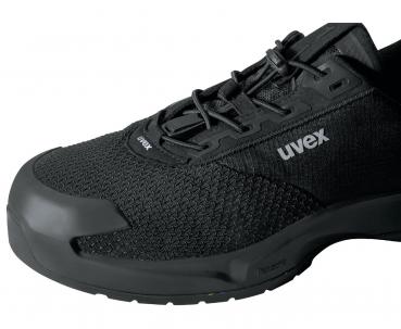 The picture shows a black work or sports shoe. It features a breathable mesh upper and a sturdy rubber cap at the tip. The laces ensure a secure fit.