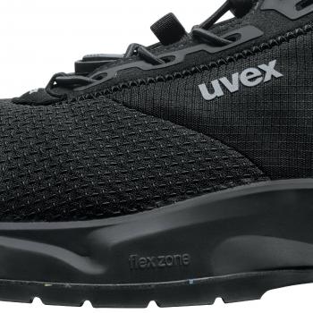 The image shows a black sports shoe with a textured upper. The sole is slightly curved and has the inscription "flexzone". The design appears modern and sporty.