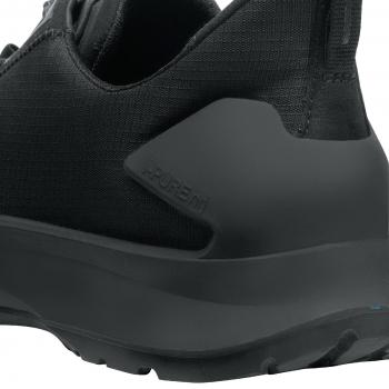 The image shows the rear part of a black sports shoe. It has a smooth, sturdy sole and a breathable textile upper. The design is modern and sporty.