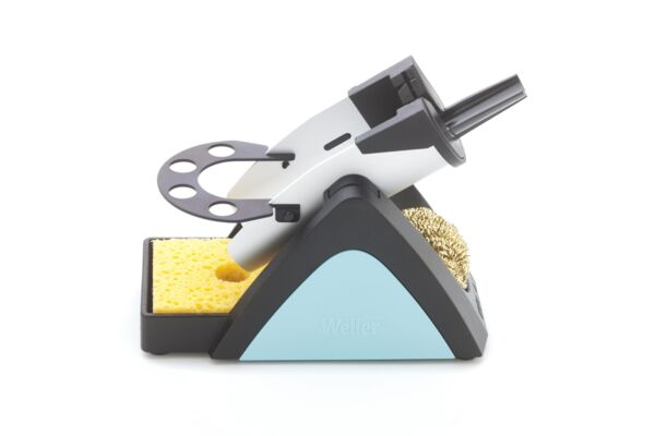 The image shows a soldering stand with a soldering tip, a sponge, and a brass cleaning brush. The stand has a triangular base and is designed in black and blue.