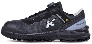 The shoe is black with gray accents and has a round shape. It features a strong treaded sole and a quick lacing system. Ergonomically designed for high comfort and support.