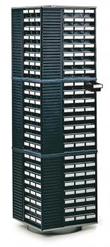 The image shows a tall, slender storage cabinet with multiple drawers and compartments. It is in dark green and has a rotating base. The compartments are labeled.