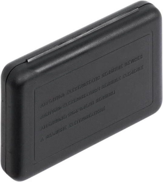 The image shows a small, rectangular, black casing with rounded edges. On the surface are various raised inscriptions that contain warnings.