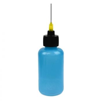 The image shows a bottle that is blue and has a black cap. A thin metal nozzle with a yellow tip protrudes from the cap. The bottle has a round shape.