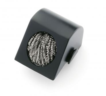 The image shows a black, slanted block with a round opening. Inside, there is a silver metal grid. It could be a cleaning brush.