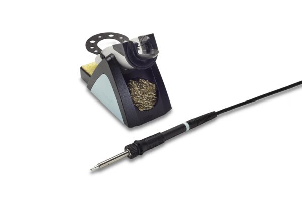 The image displays a soldering iron kit. On the right is a soldering iron with a black handle and a metallic tip. On the left, there is a stand with a yellow sponge.