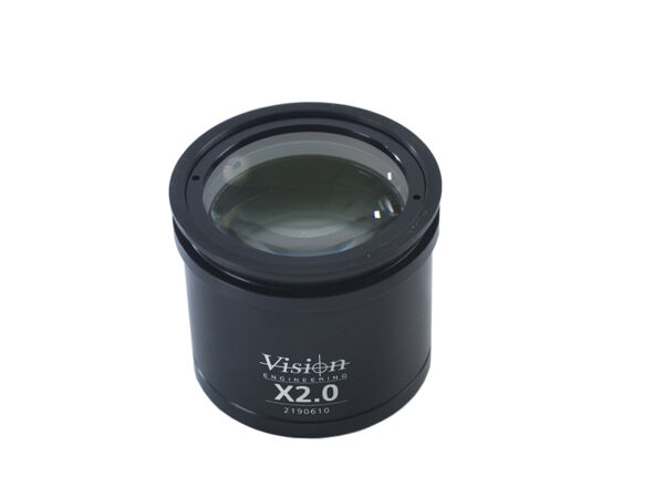 The image shows a cylindrical lens attachment in black. It has a smooth surface and a clear lens in the center, below which 