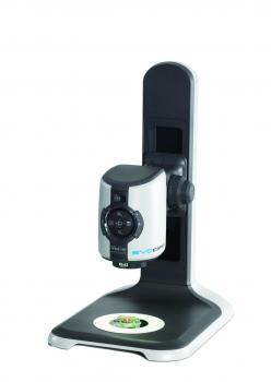 The image shows an electric magnifying device on a sturdy, black stand. It features a round, illuminated area for objects and a camera with controls on top.