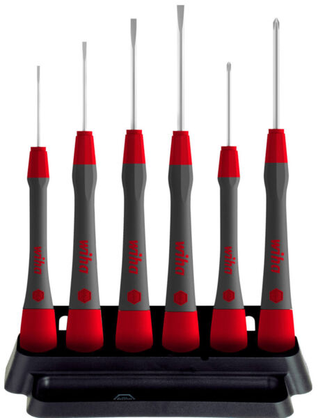 The image shows a set of six screwdrivers in a holder. The handles are gray with red accents. The screwdrivers have narrow, long tips pointing in different directions.