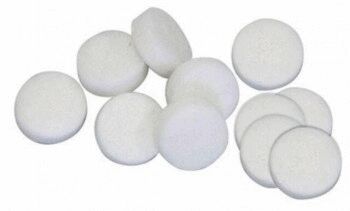 In the picture, there are several small, round, white tablets on a surface. They are smooth-skinned and have a uniform shape, with some overlapping each other.