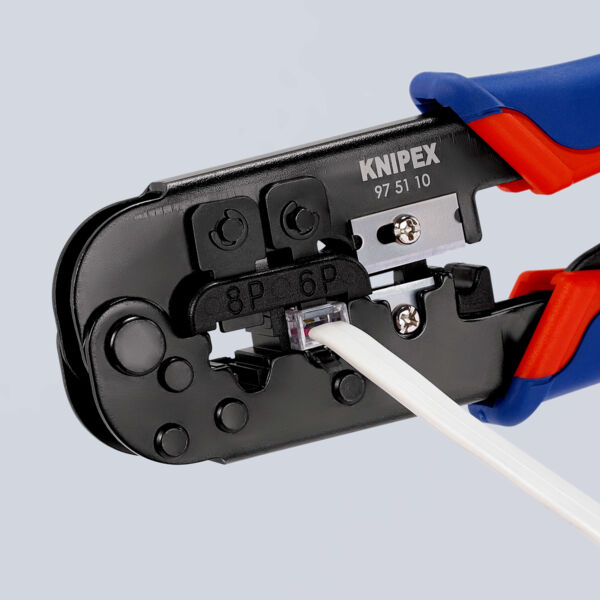 The image shows a cable cutter or crimping tool in black and blue. A thin, white cable is inserted while the tool is open, ready for crimping or cutting.