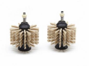 The image shows two round brush attachments. They have a black base with numerous light bristles arranged symmetrically. Each brush has a small spring on top.