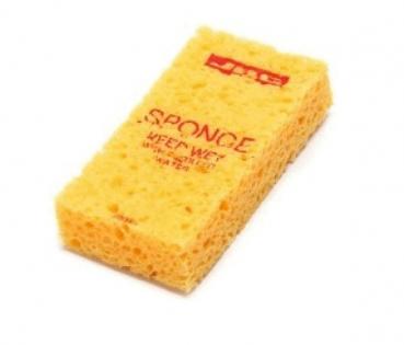 The image shows a yellow sponge. It is rectangular and has a porous, soft texture. On the front, the word "SPONGE" is written in red letters.