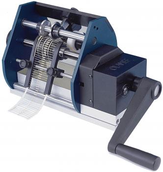 The image depicts a manual machine with a handle. It features two rollers and an area where paper strips are processed. The mechanism appears sturdy and functional.