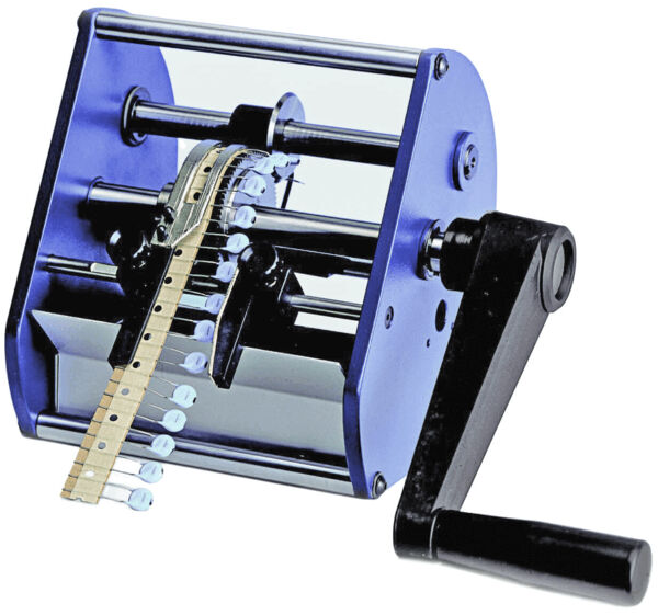 The image shows a manual machine with a large, rectangular casing and a crank. At the front, a flexible band runs through the machine, which has rotating mechanisms in the center.