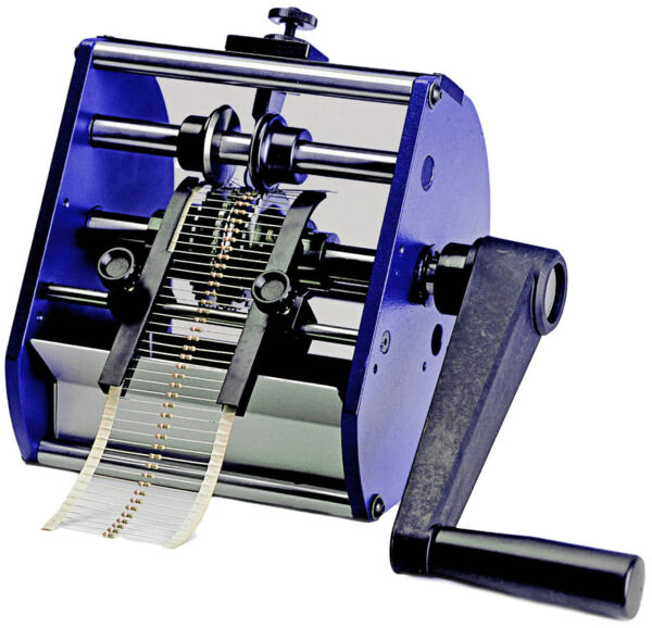 The image shows a mechanical device with a hand crank. Two rollers grasp a long, narrow strip that slides through the device. The colors are predominantly blue and black.