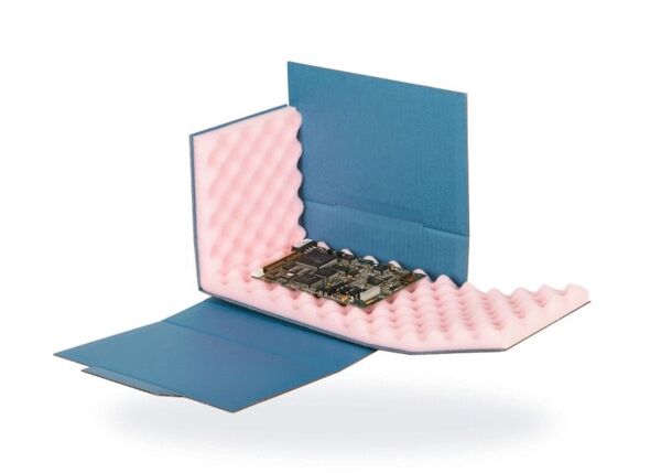 The image shows an electronic circuit board encased in a protective box made of blue cardboard and pink foam. The structure serves to protect the circuit board.