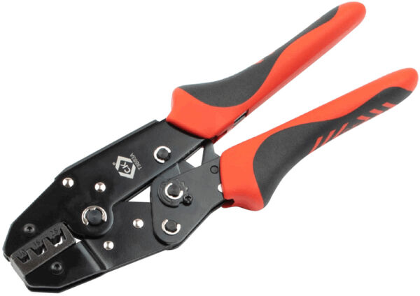 The image shows a crimping tool with black and red handles. It has two movable arms, a flat resting surface, and various notches for different wire sizes.