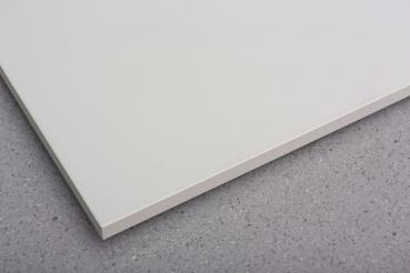 The image shows a smooth, white plate lying on a gray, textured surface. The edges of the plate are slightly rounded. It features a minimalist design.