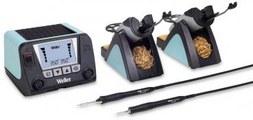 The image shows a soldering station with a digital display, two soldering tip holders, and two soldering tips. They are designed in black and turquoise blue, with a placed sponge cleaning.